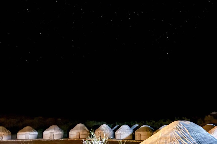 A row of covered structures against a night sky. 1