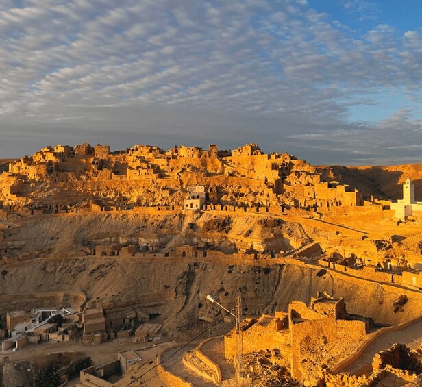 A historic cityscape with ancient ruins and a prominent white minaret. 5