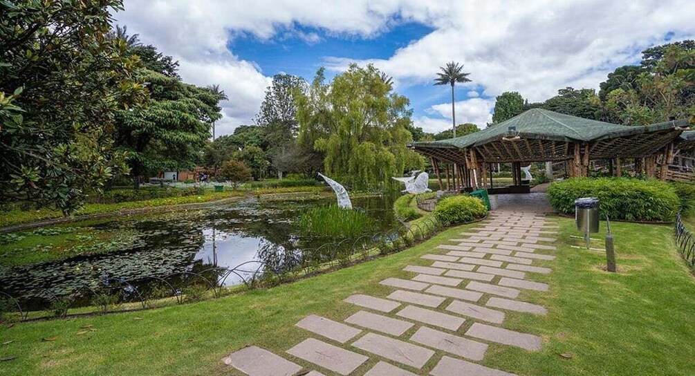 A garden with a pond, a gazebo, and a stone pathway. 5