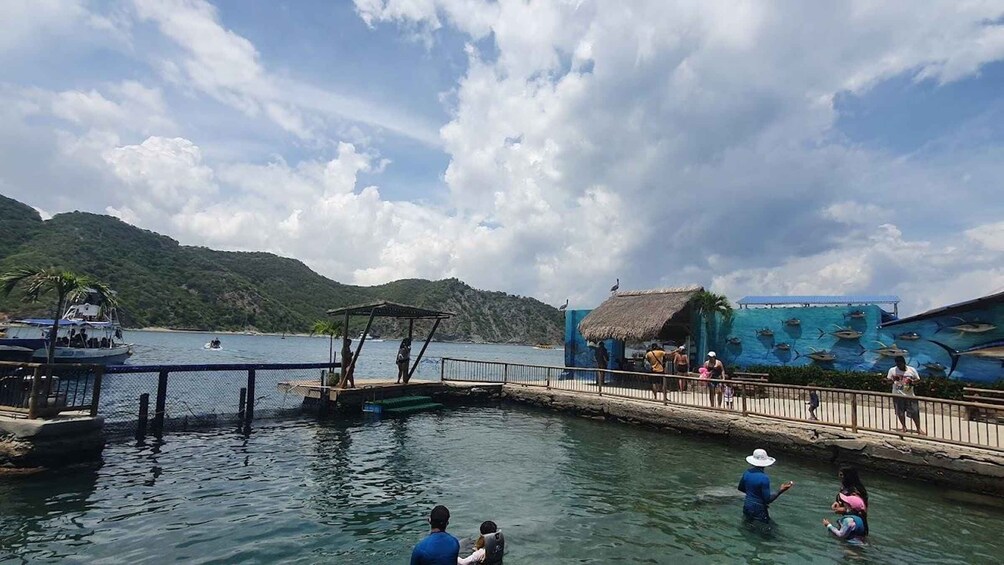 A lake with boats, a dock, and people swimming. 2