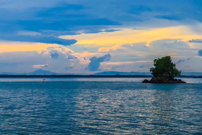 A calm lake with a small island and a distant mountain range. 3