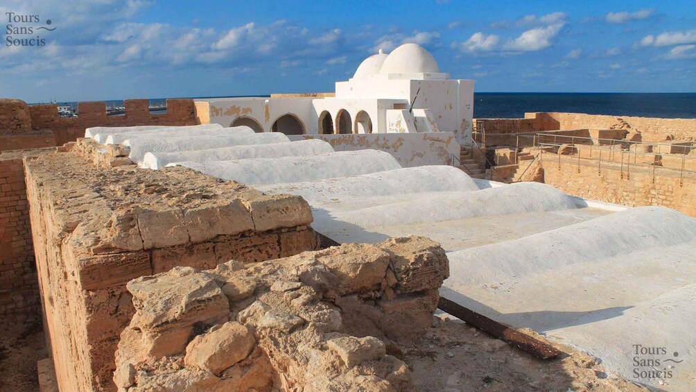 Ancient ruins with whitewashed walls and a dome structure. 2
