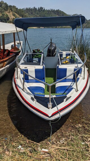 A boat docked at a pier with a forested hill in the background. 4