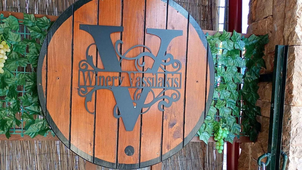 A wooden barrel with the inscription 'Wineries Vassilakis' and decorative vines. 5