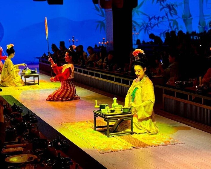 A traditional Chinese opera performance with actors in period costumes on a stage. 2