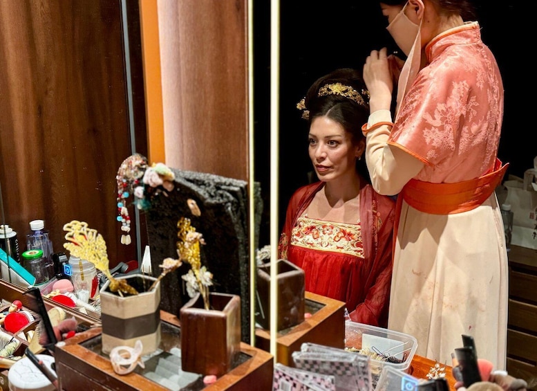 A person in traditional attire, a makeup table with various items, and a mirror. 4