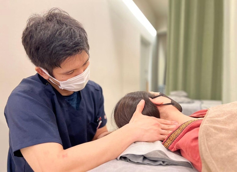 A medical professional attending to a patient on a treatment bed. 4