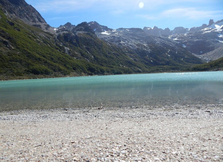 A clear mountain lake with rocky shores and surrounding peaks. 4