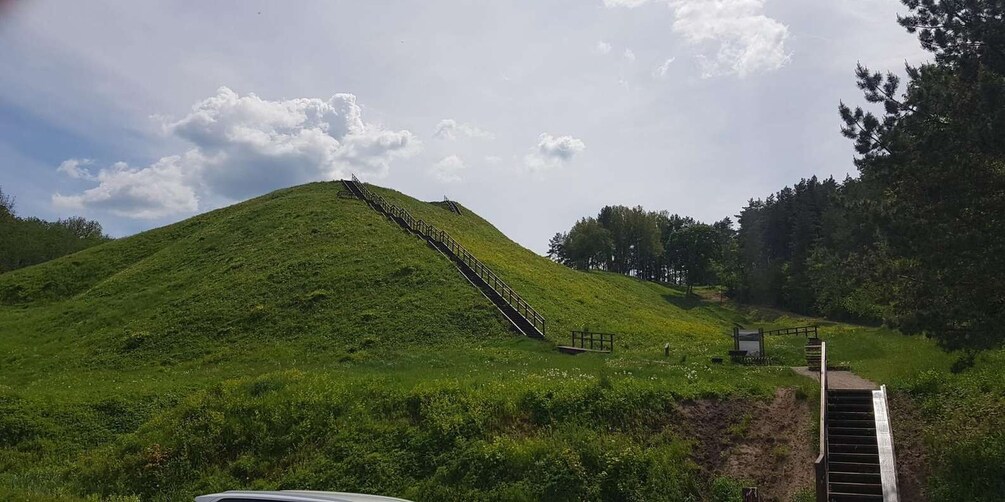 A grassy hill with a staircase leading up to the top. 4