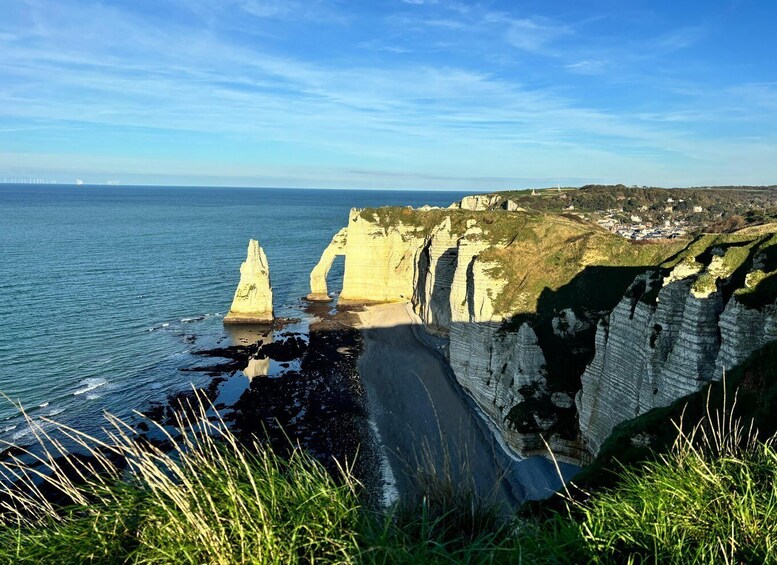 Coastal cliffs, a beach, and a distant village. 1