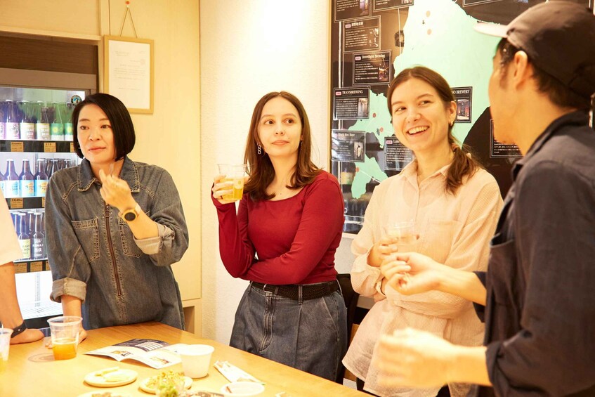 A group of people at a bar with drinks and a menu. 1