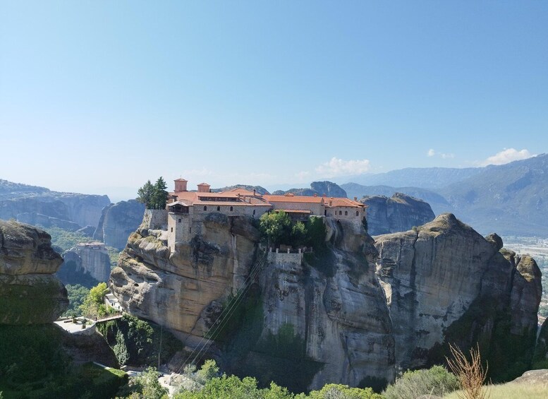 A monastery perched atop a cliff with a clear view of the surrounding landscape. 5