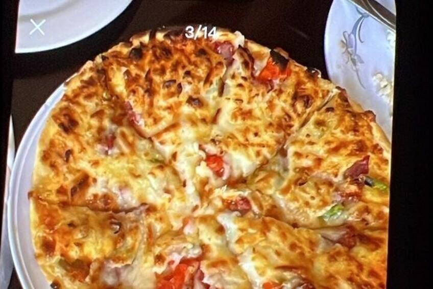 A pizza with visible toppings and a date stamp. 4