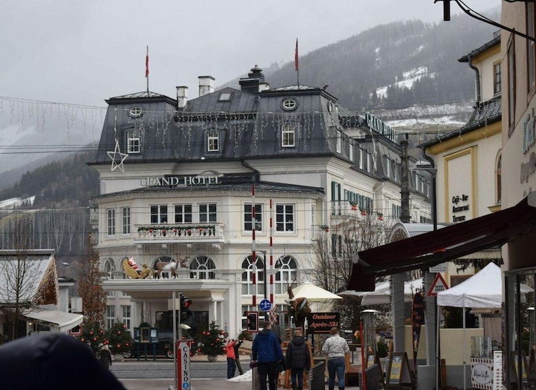 A historic building labeled 'Grand Hotel' with a balcony decorated for Christmas, surrounded by a snowy mountain backdrop. 5