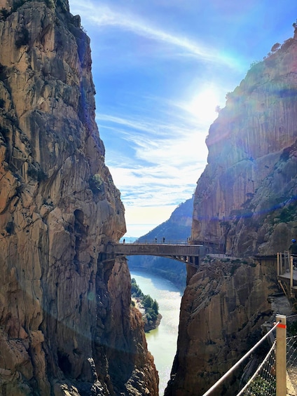 A stone bridge spanning a river canyon with steep cliffs on either side. 1