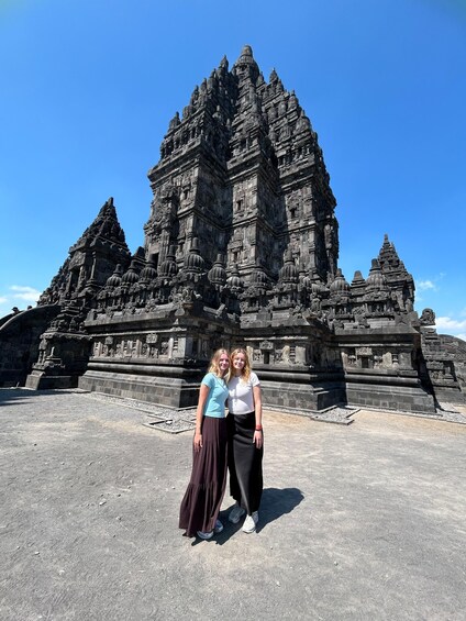 A temple with intricate carvings and two people standing in front. 5