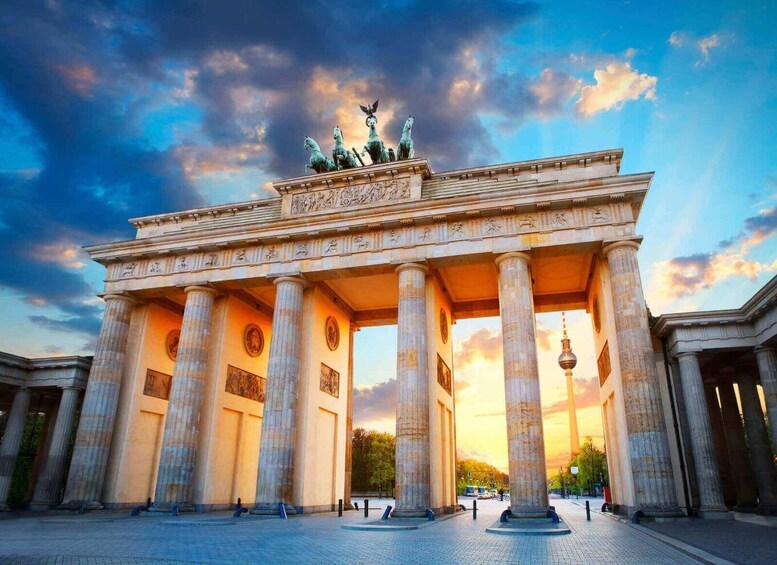 The Brandenburg Gate with its classical architecture and statues, set against a sunset sky. 1