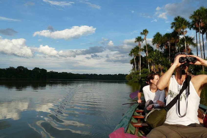 A boat on a calm lake with palm trees in the background. 1