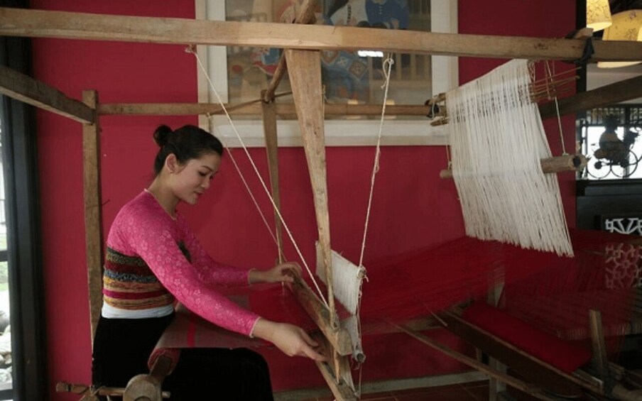 A person weaving on a traditional loom. 4