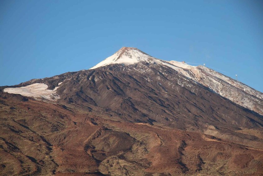 A mountain with a snow-capped peak and a barren landscape. 2