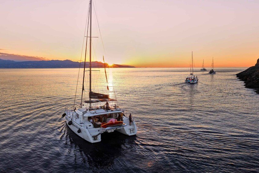 A sailboat with passengers on a calm sea at sunset. 5