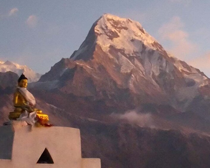 A statue of a figure on a pedestal with a snow-capped mountain in the background. 1