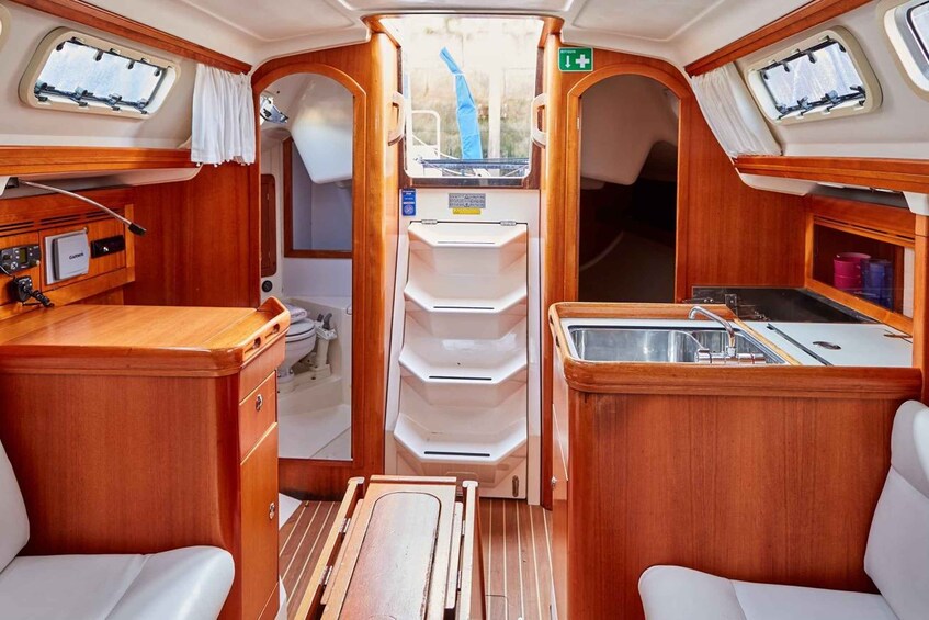 A compact kitchen with wooden cabinetry, a sink, and a small countertop. 5