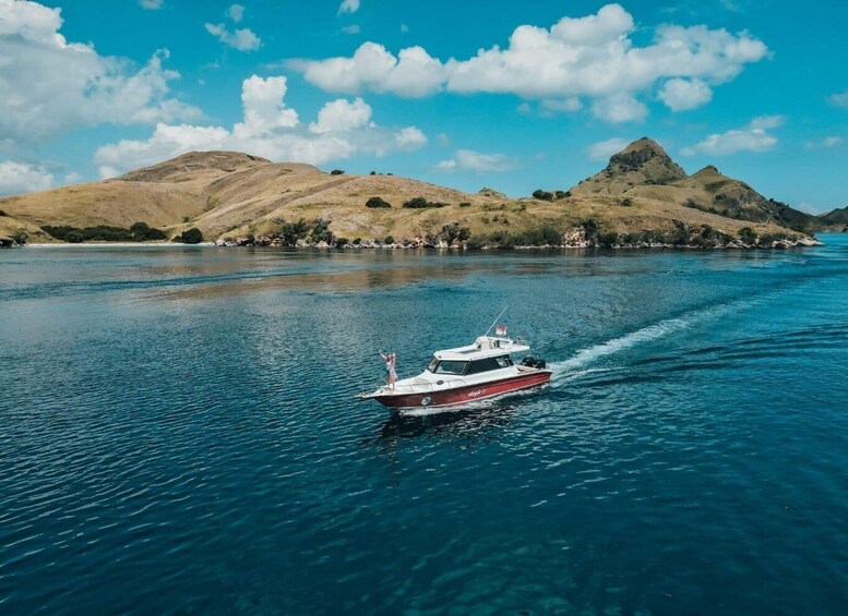 A boat on a calm river with hills in the background. 1