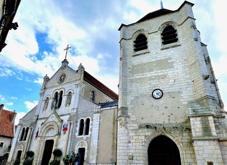 A historic church with a bell tower, a clock, and a weather vane. 1
