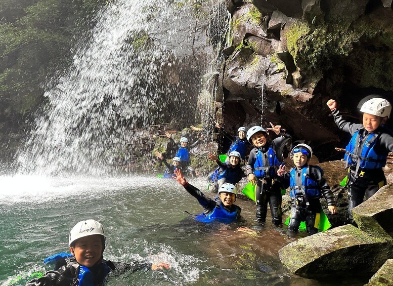A group of people in water with a waterfall in the background. 5