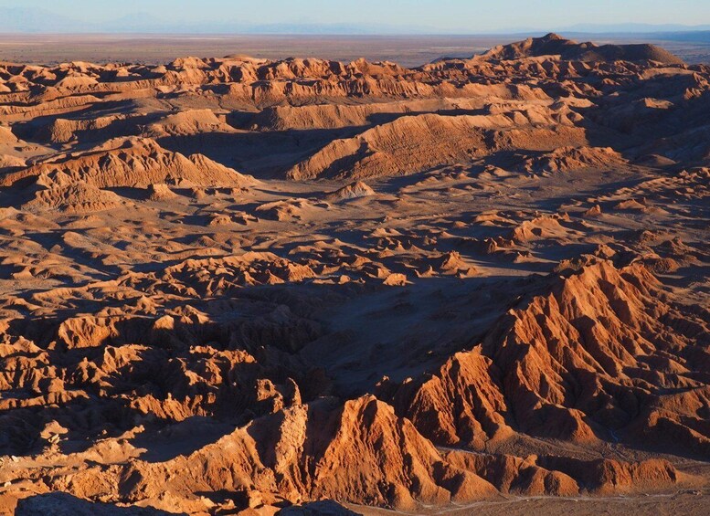 Un extenso paisaje desértico con colinas y valles escarpados y erosionados. 3