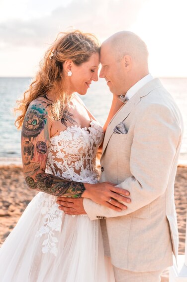A couple on a beach, with tattoos visible on the woman. 2