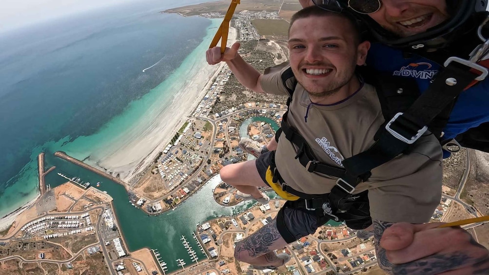 A person bungee jumping with a cityscape and coastline in the background. 5