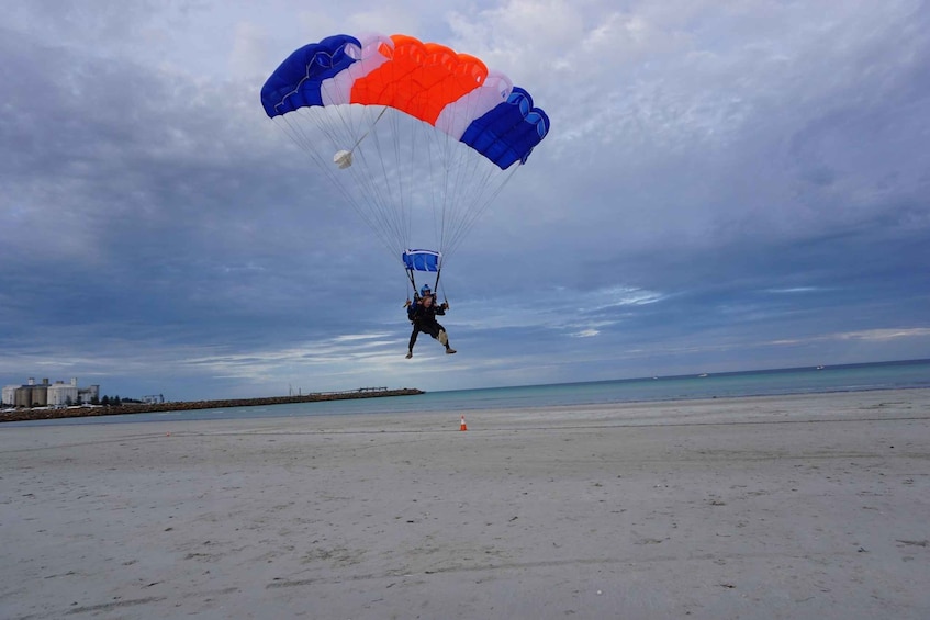 A person paragliding over a beach with a colorful parachute. 4