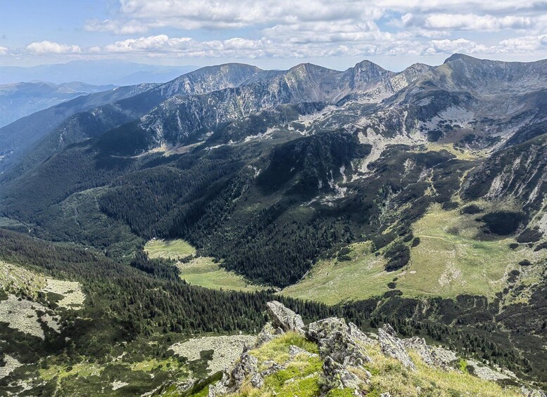 A mountainous landscape with dense forests and rocky terrain. 2