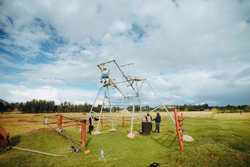 A large metal structure in an open field with people working on it. 4