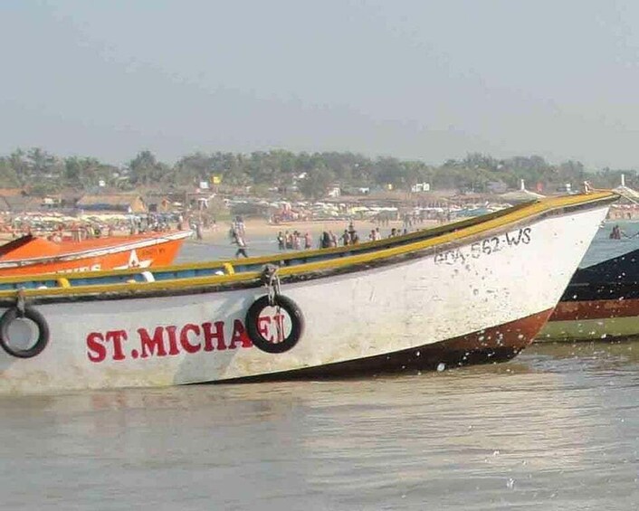 A boat named 'ST.MICHAEL' docked at a beach with a crowd in the background. 5