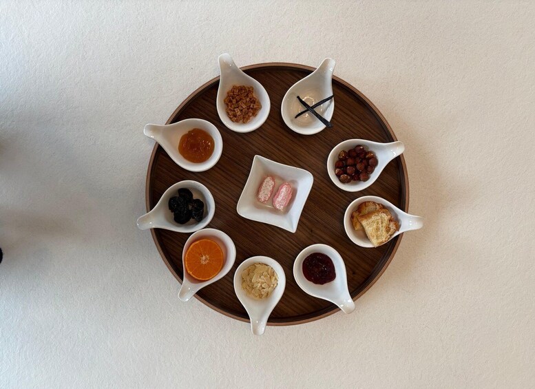 A wooden tray with various food items in white spoons. 2