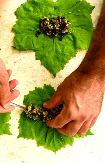 Hands preparing food on a leaf. 3
