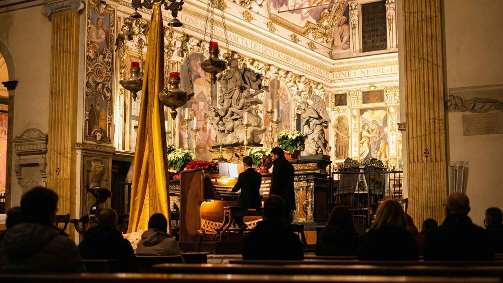 Interno di una chiesa finemente decorata, con un coro che esegue. 5