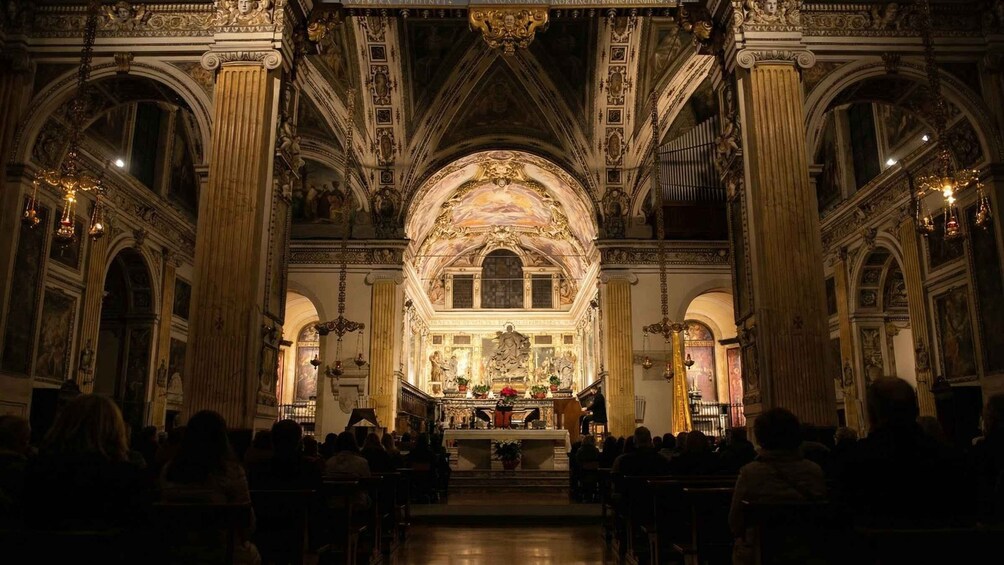 An ornate church interior with high ceilings, detailed frescoes, and a central altar. 5