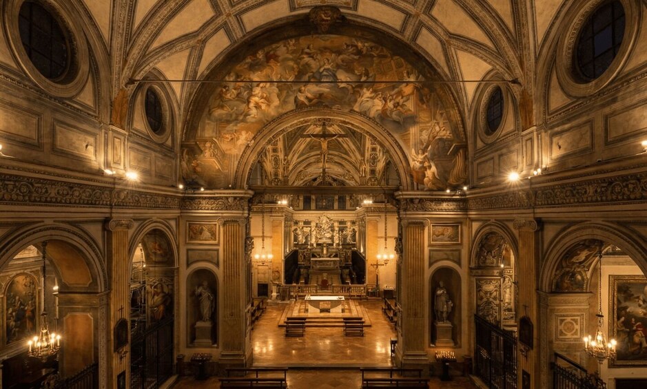 Interno di una chiesa decorata, con soffitto a volta alto, affreschi dettagliati e un altare centrale. 4