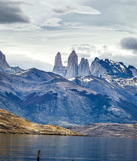 A mountainous landscape with a lake in the foreground and snow-capped peaks in the background. 1