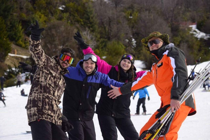 A group of people on a snowy slope with skis and snowboards, indicating a winter sports area. 2