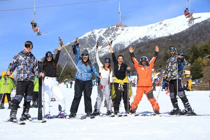 A group of skiers on a snowy slope with ski lifts in the background. 5