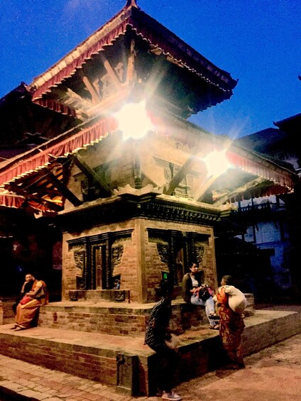 A traditional building with a tiled roof and a small shrine-like structure in front. 4