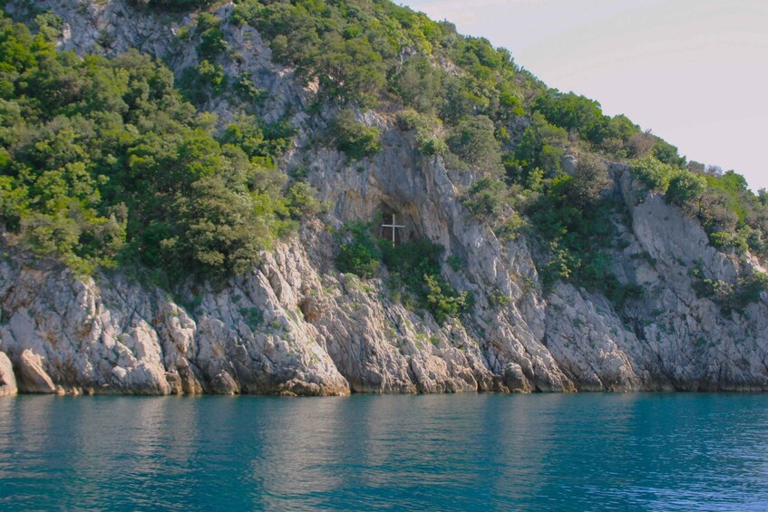A coastal landscape with a rocky cliff and a cross. 4