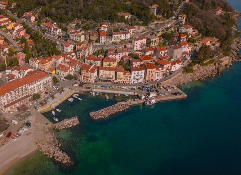 A coastal town with colorful buildings, a marina, and a rocky shoreline. 1