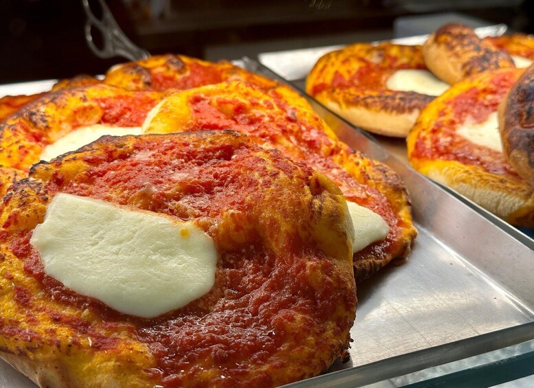A tray of pizzas with melted cheese and tomato sauce. 5