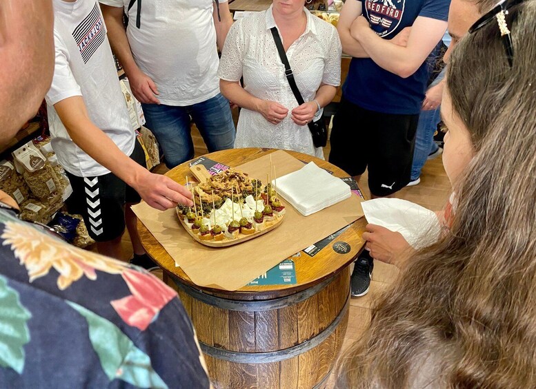 A person serving a dessert on a wooden table in a public setting. 1